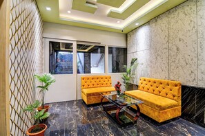Een modern interieur met een zithoek, een glazen salontafel en potplanten.