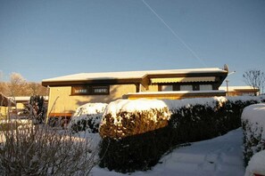 Ein zweistöckiges Gebäude mit Flachdach und Satellitenschüssel.