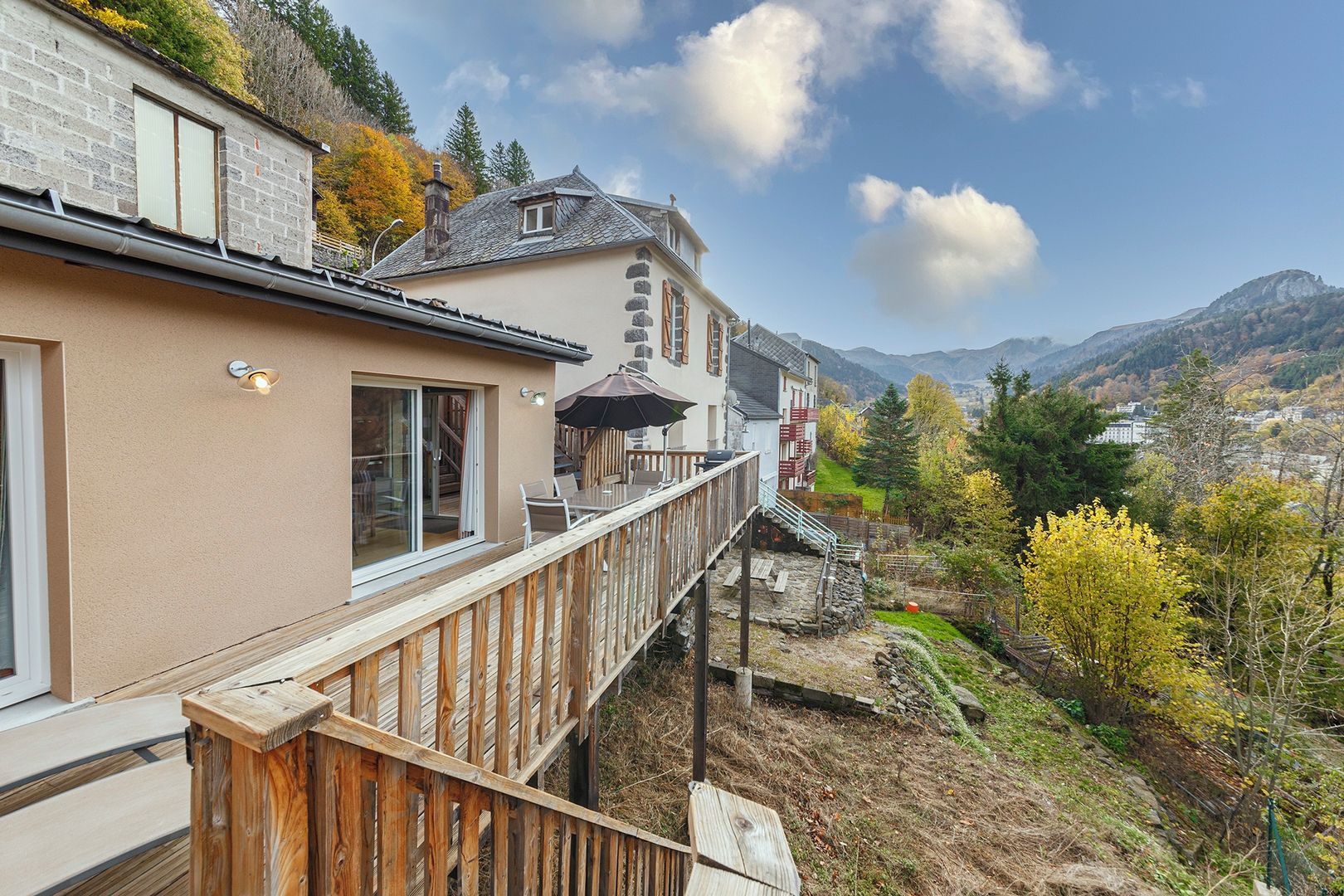 Uma casa com varanda e vista para uma paisagem montanhosa.