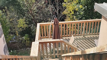 A wooden staircase leading down to a pool area with a metal safety handrail.