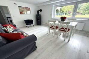 Un salon moderne avec un canapé, des fauteuils, une table et une cheminée.