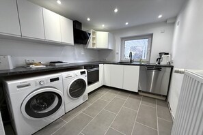 A modern kitchen with built-in appliances, including a washing machine, dishwasher, and oven. - Holiday apartment with 2 bedrooms (Preetz)