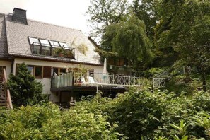 A house with a balcony, surrounded by dense greenery. - Holiday apartment in Dittmannsdorf with sauna (Dittmannsdorf)
