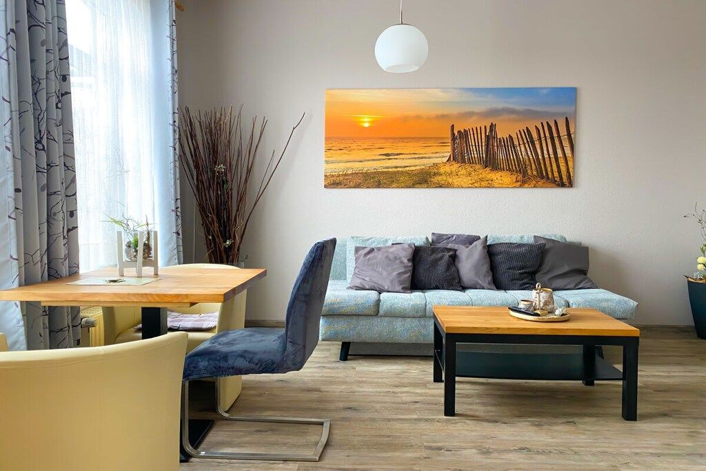 A modern living room with a sofa, a coffee table, and a dining area with chairs and a table.