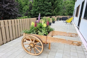 A wooden cart with plants, a wooden fence, and a building in the background. - Holiday apartment in Au with swimming pool (Au)