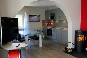 A compact living space with a dining area, kitchenette, and a TV. - Apartment in Westerland with swimming pool (Westerland)