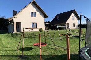 Un barrio residencial con dos casas, un césped y un trampolín.