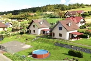 A residential area with houses, a swimming pool, and a well-maintained lawn. - Holiday home with 3 bedrooms (Jelenia Gora)