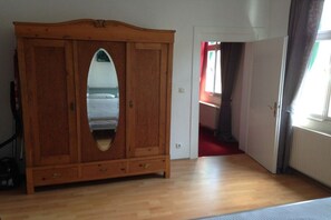 A room with a wooden wardrobe, a bed with a white bedspread, and a red carpet. - Holiday home in Ahr Valley with 1 bedroom (Ahrweiler)