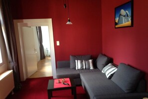 A room with a grey sofa, a small table, and a painting on the wall. - Holiday home in Ahr Valley with 1 bedroom (Ahrweiler)
