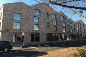 A multi-story building with a brick facade, large windows, and a visible entrance. - Holiday apartment in Celle with Wi-Fi (Celle)