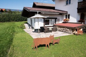A house with a patio, a small shed, and a cow sculpture. - Holiday apartment in Fischen-Berg with Wi-Fi (Fischen- Berg)