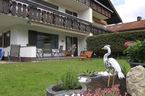 Ein zweistöckiges Gebäude mit Balkon, Außenbereich und einer Vogelstatue.