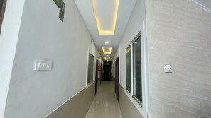 A hallway with a light-colored floor, a ceiling with recessed lighting, and a door at the end. - Collection O Vijay Nagar Square Indore (Indore)