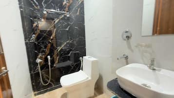 Un baño con inodoro, lavabo y ducha.