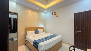 A bedroom with a bed, a wooden wardrobe, and a mirror. - Collection O Vijay Nagar Square Indore (Indore)