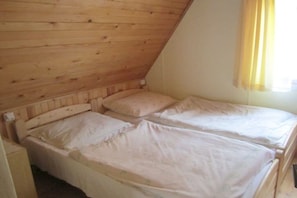A small, single-room accommodation with a sloped ceiling and two beds. - Holiday home by the lake (Milevsko)