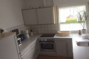 Une cuisine de taille réduite équipée d’une cuisinière, d’un four et d’un évier.