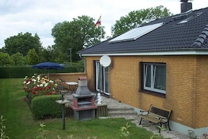 A brick house with a satellite dish, a chimney, and a bench. - Holiday home with 2 bedrooms (Tetenbüll)