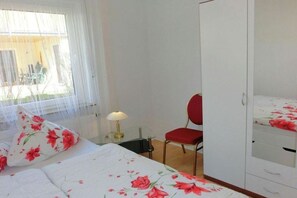 A bedroom with a bed, a chair, a desk, and a wardrobe. - Vineyard Bad Wildungen (Bad Wildungen)