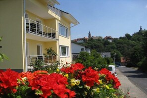 A yellow building with a balcony, surrounded by greenery and a clear sky. - Vineyard Bad Wildungen (Bad Wildungen)