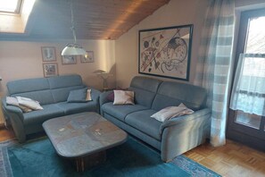 A living room with two sofas, a coffee table, and a painting on the wall. - Holiday apartment with 1 bedroom (Teisnach)