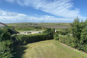 A residential property with a well-maintained lawn, a small garden area, and a view of the surrounding countryside. - Holiday apartment with 4 bedrooms (JULIANADORP)