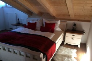 A bedroom with a bed, a nightstand, a lamp, and a fur rug. - Holiday apartment in Seeg with swimming pool (Seeg)