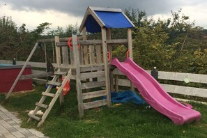 A wooden play structure with a slide and a climbing ladder. - Holiday apartment in Seeg with swimming pool (Seeg)