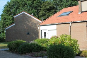 A two-story building with a brick facade and a red-tiled roof. - Holiday home with 2 bedrooms (Bruinisse)