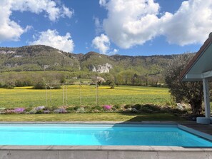 Une piscine offrant une vue sur un paysage montagneux et un ciel dégagé.
