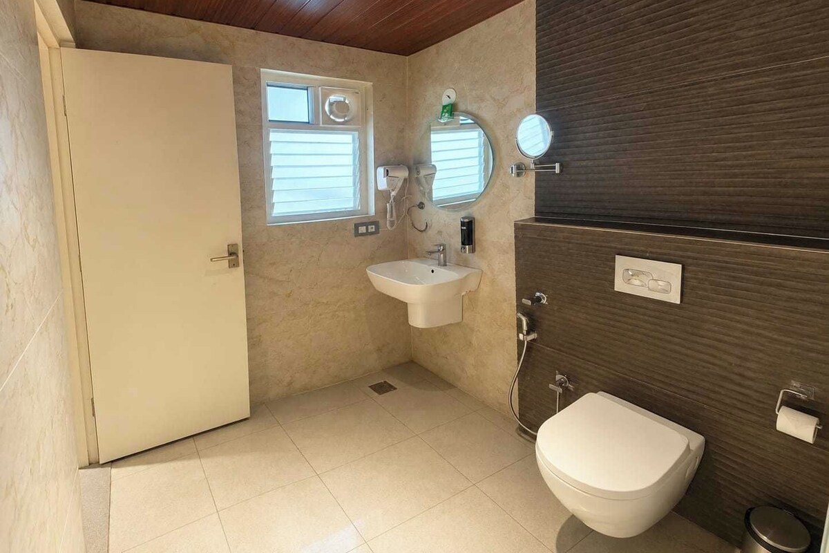 A bathroom with a toilet, sink, and mirror.