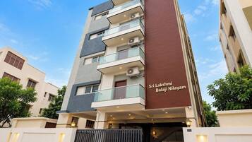 Un hotel de varios pisos con diseño moderno, que cuenta con balcones y unidades de aire acondicionado.