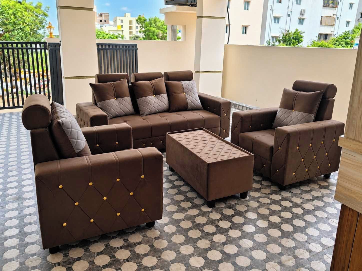 Un área de estar exterior moderna con un conjunto de sofás y una mesa de centro, con piso de diseño geométrico.