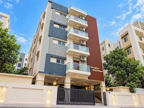 A multi-story hotel with balconies, a name sign, and a gated entrance. - Hotel O Tirumala Hill View Tirupati (Tirupati)
