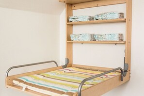 A bed with a metal frame and a wooden headboard, featuring a striped bedding. - Holiday apartment in Büsum with swimming pool (Büsum)