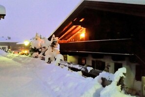 A building with a sloped roof and a snow-covered pathway leading to its entrance. - Holiday apartment with 2 bedrooms (Hochkrimml)