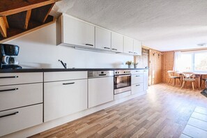 Eine moderne Küche mit weißen Schränken, Edelstahlgeräten und Holzboden.