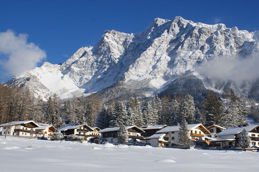A snow-covered mountain with a chalet-style building complex in the foreground.