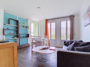 A modern living room with a round table, a sofa, and a bookshelf. - Quiet apartment on the 4th floor (Saint-Brieuc)