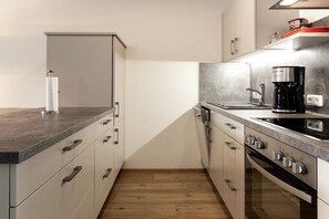 Eine moderne Küche mit Backofen, Kaffeemaschine und Arbeitsplatte.