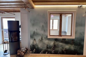 Ein Zimmer mit Kamin, Fenster und Wandgemälde.
