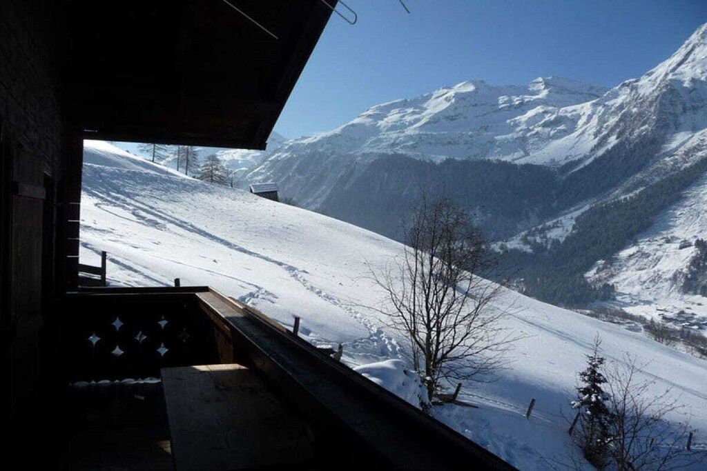 A snow-covered mountain landscape viewed from a building's window.