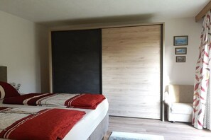Un dormitorio con una cama, una silla y una puerta corredera.