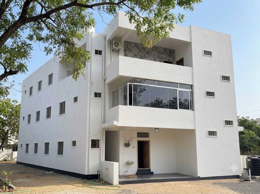 Un edificio moderno de dos pisos con fachada plana, ventanas amplias y un balcón.