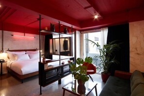 A modern hotel room with a bed, a desk, a chair, and a large window. - Max Brown Hotel Downtown, part of Sircle Collection - Suite (Athens)