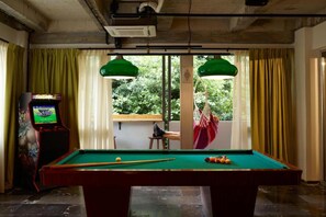 A pool table with balls, a pool cue, and a video game machine in a room with windows and curtains. - Max Brown Hotel Downtown, part of Sircle Collection - Deluxe Double Room (Athens)