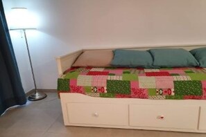 A bed with a quilt, two pillows, and a bedside drawer. - Flat with Pool Views in Corralejo (Corralejo)