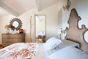 A bedroom with a bed, dresser, mirror, and a door leading to another room. - Villa 'La Bergerie' with Sea View, Wi-Fi and Air Conditioning (Coti-Chiavari)