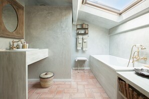 A modern bathroom with a skylight, a freestanding bathtub, and a vanity with a sink. - Villa 'La Bergerie' with Sea View, Wi-Fi and Air Conditioning (Coti-Chiavari)